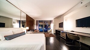 A modern hotel room with a large bed, a desk, a TV, and a city view. - SVS: Strip View Studio | Open Balcony | Pool & Gym Access | Palms Place (Las Vegas)