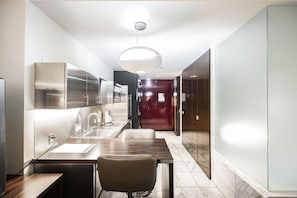 A modern kitchen with stainless steel appliances, a marble countertop, and a pendant light. - SVS: High Floor Strip View Studio | Open Balcony | Palms Place (Las Vegas)