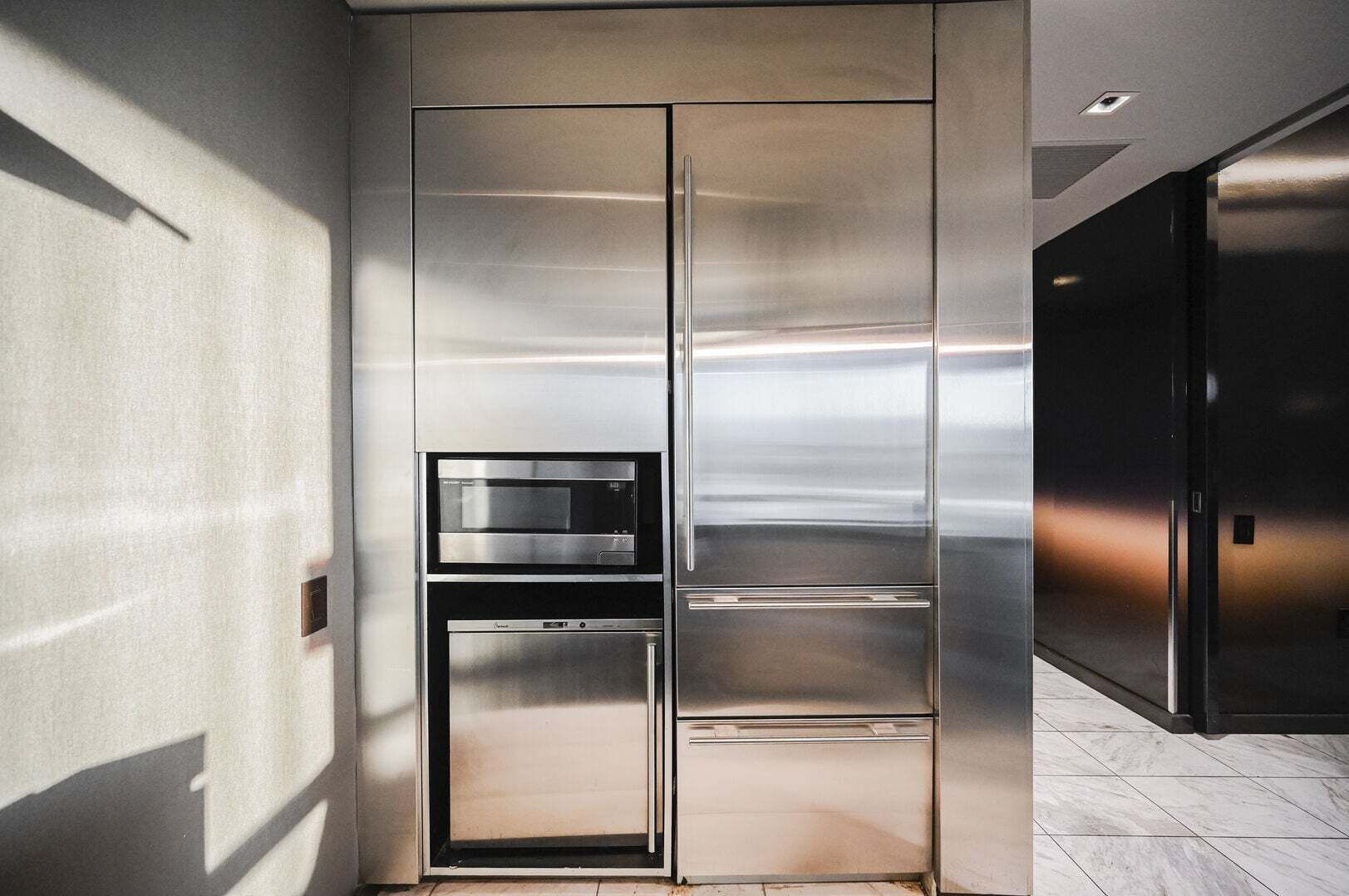 Eine moderne Küche mit Edelstahlgeräten, einem Backofen und einer Mikrowelle.