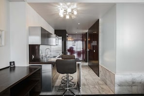 A modern kitchen with a bar area, stainless steel appliances, and a glass door leading to another room. - Strip View Studio • Balcony • No Resort Fee • Free Parking • TD53 (Las Vegas)