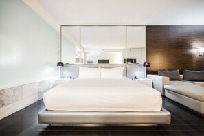 A modern hotel room with a large bed, bedside tables, a sofa, and a large mirror. - Palms Place Studio, Strip Views & Balcony Options (Las Vegas)