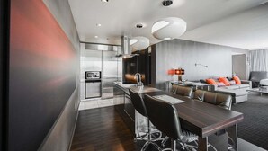 Moderni hotellihuone, jossa on ruokailutila, keittiö ja oleskelutila.