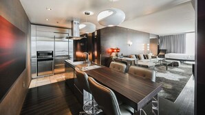 A modern hotel room with a dining area, a kitchenette, a sofa, a bed, and a large window. - SVS: 1BD Strip View | Jetted Tub | Full Kitchen | Sleeps 6 | Palms Place (Las Vegas)