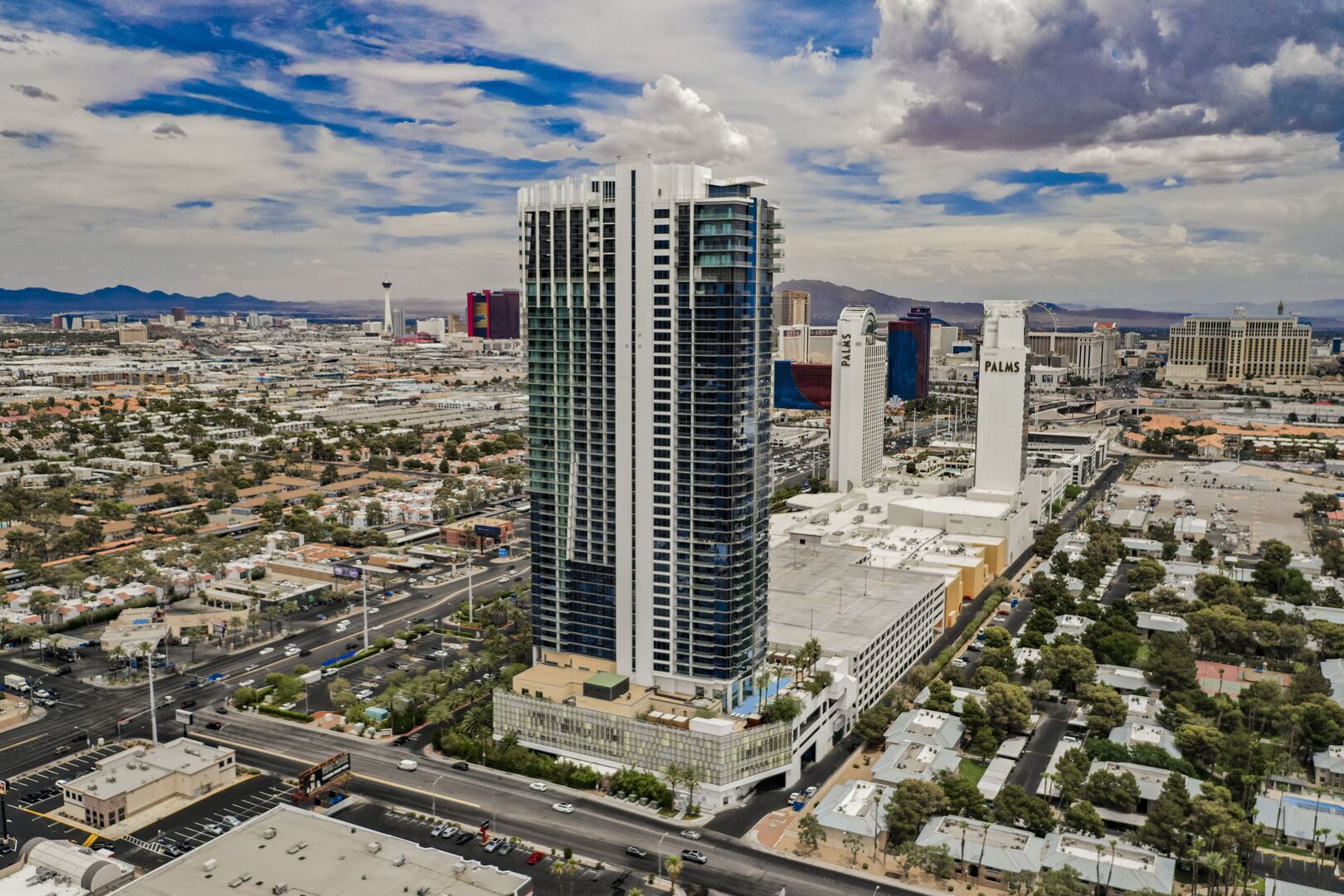 Ein Hochhaus mit moderner Glasfassade, umgeben von einer Mischung aus Geschäfts- und Wohngebäuden.
