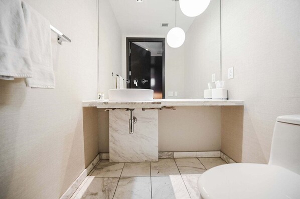 Ein modernes Badezimmer mit Waschbecken, Spiegel und Toilette.