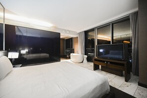 Quarto de hotel moderno com uma cama grande, televisão de tela plana, banheira e vista para a cidade.