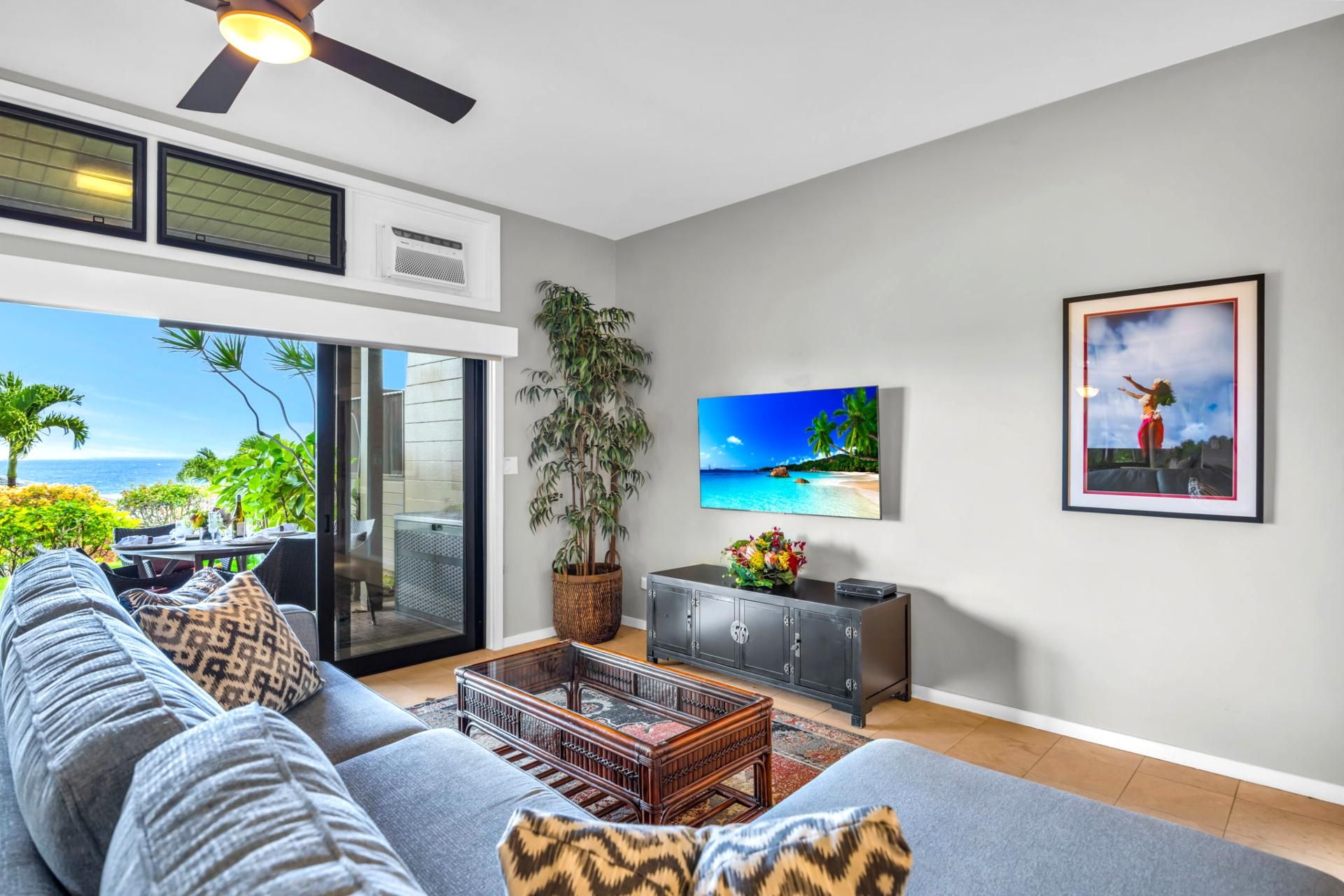 A living room with a sofa, a coffee table, a TV, a cabinet, and a plant.