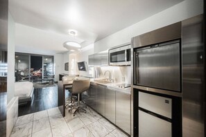 A modern kitchen with stainless steel appliances, a bar area, and a city view. - Strip View Studio • Balcony • No Resort Fee • Free Parking • TC9 (Las Vegas)