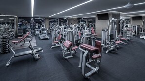 A modern gym with various exercise machines, mirrors, and a ceiling fan. - Palms Place Studio | Strip View & Balcony (Las Vegas)
