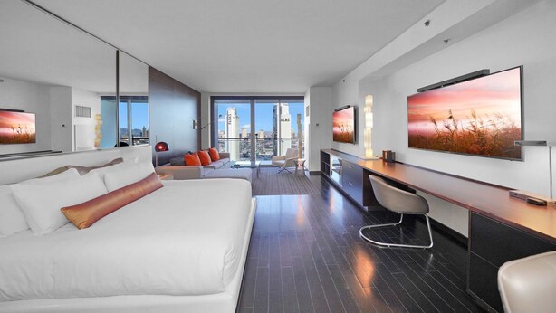 Een moderne hotelkamer met een groot bed, een bureau, een stoel en een televisie.