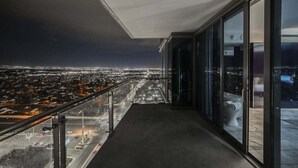 Ein Balkon mit Blick auf die nächtliche Stadt.