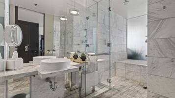 Ein modernes Badezimmer mit zwei Waschbecken, einer Glasdusche und Marmorboden.