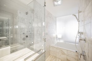 A modern bathroom with a glass-enclosed shower, a bathtub, and marble tiles. - Strip View Studio • Balcony • No Resort Fee • Free Parking • TI32 (Las Vegas)