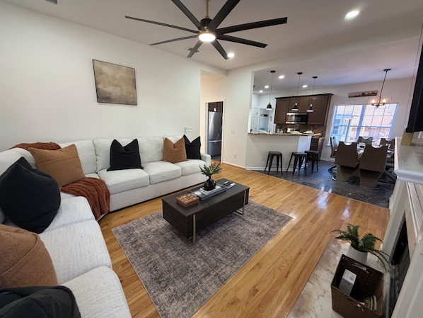 A modern living room with a sofa, coffee table, and a ceiling fan.
