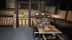 An outdoor dining area with a wooden table set for four, surrounded by chairs, and a sign reading 'Welcome to our PORCH'. - GHome, Modern Cozy 5BR 10BEDS located  in Lilburn, GA with AC perfect for family (Lilburn)