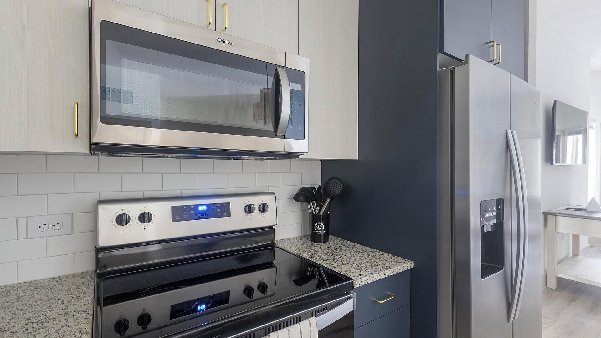 A modern kitchen with stainless steel appliances, a microwave, oven, and refrigerator.