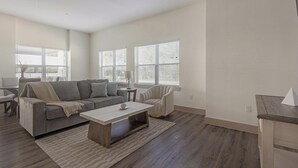 Een woonkamer met een bank, salontafel en een eethoek met tafel en stoelen.