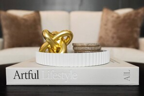 Ein Buch mit dem Titel 'Artful Lifestyle', verziert mit einem goldenen Gegenstand und einer Münze darauf.
