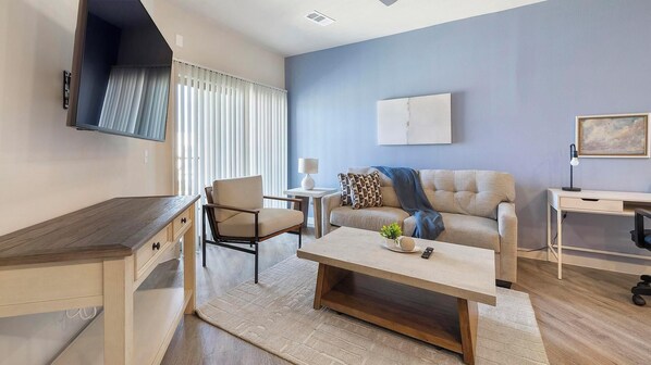 Un salon moderne avec un canapé, une table basse et un bureau.