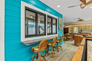 A bar area with wicker chairs, a pool table, and a ceiling fan. - Luxury Oceanfront Escape w/ Spa & Chef's Kitchen (Surfside Beach)