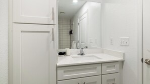 A bathroom with a white sink, mirror, and cabinets. - Landing | Chic Studio, Clubhouse, Gym (Kissimmee)