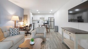 Eine moderne Wohnung mit Wohnzimmer, Essbereich und Küche.