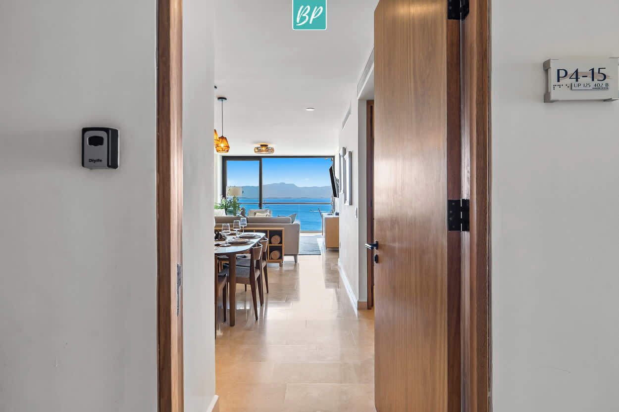 Un couloir d’hôtel menant à une salle à manger avec vue sur la mer.