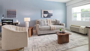 Un salon comprenant un canapé, un fauteuil, une table basse et un radiateur.