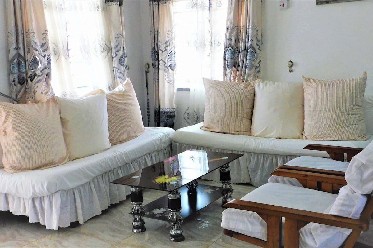 A living room with a sofa set, a coffee table, and a wooden chair.