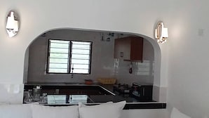 A modern living room with a sofa, a coffee table, and a ceiling fan. - Kigotho Hotel & Apartments (Mombasa)