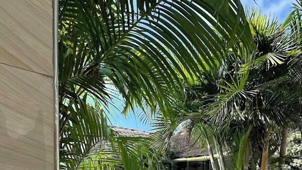 A swimming pool surrounded by palm trees and a covered area. - Kigotho Hotel & Apartments (Mombasa)