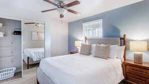 A bedroom with a bed, nightstands, a ceiling fan, a window, and a closet. - Landing | Chic 2BD, Clubhouse, Gym (Tallahassee)