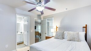 A bedroom with a bed, a ceiling fan, and a view of the hallway. - Landing | Spectacular 2BD, Game Room, Clubhouse (Tallahassee)