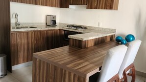 Una cucina moderna con mobili in legno, un'isola centrale e una zona pranzo con sedie.