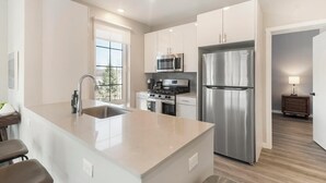 Una cocina moderna con un refrigerador de acero inoxidable, un microondas y una estufa.