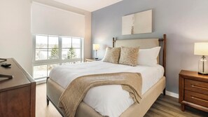 A bedroom with a bed, bedside tables, a lamp, a window, and a painting on the wall. - Landing | Modern 2BD, Game Room, Yoga Studio (New Haven)