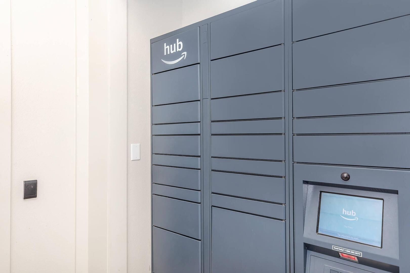 A grey Hub station with a screen displaying the Hub logo and a help button.