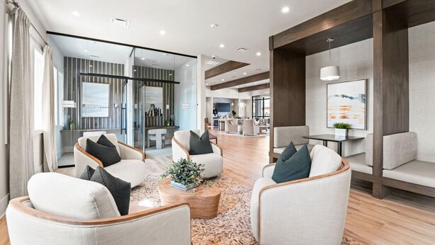 A modern hotel lobby with seating areas, a coffee table, and a view into the dining area. - Landing | Incredible 2BD, Gym (Longs)