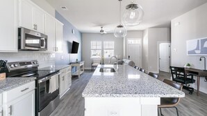 A modern kitchen with granite countertops, stainless steel appliances, and a central island. - Landing | Incredible 2BD, Gym (Longs)