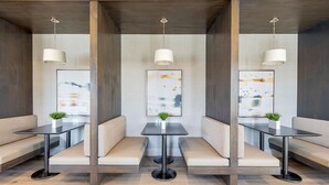 A modern interior with three seating areas, each with a table and a hanging light fixture. - Landing | Incredible 2BD, Gym (Longs)