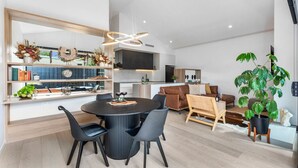 Un espace de vie moderne comprenant un coin repas, une cuisine et un coin salon.