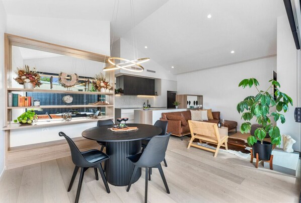 A modern living space with a dining area, kitchen, and seating area.