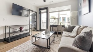 Uma sala de estar moderna com sofá, mesa de centro e televisão.