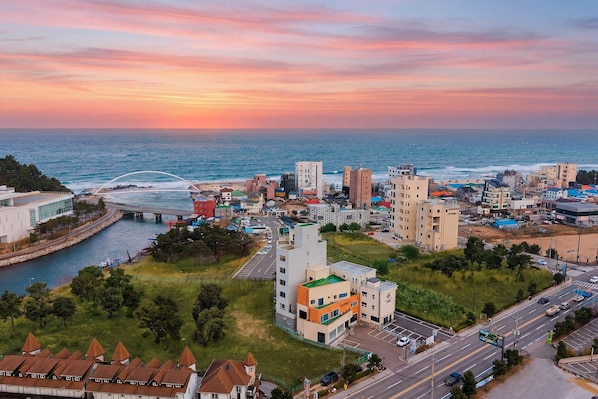 A coastal cityscape with modern buildings, a marina, and a bridge. - Gangneung Gangmun Stay (Gangneung)