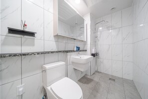 A modern bathroom with a toilet, sink, and shower. - Gangneung Gangmun Stay (Gangneung)