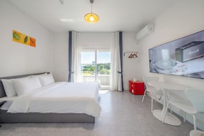 A modern hotel room with a bed, a desk, a flat-screen TV, and a view of the outdoors. - Gangneung Gangmun Stay (Gangneung)