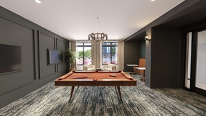 Une chambre moderne équipée d’une table de billard, d’un téléviseur et d’une grande fenêtre donnant sur l’extérieur.