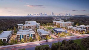 Un moderno complejo residencial con varias edificaciones, un patio central y una vista del horizonte urbano al fondo.