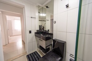 Une salle de bain avec un grand miroir, un lavabo et des toilettes.