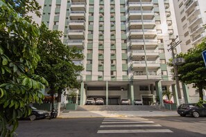 Un immeuble à plusieurs étages doté de balcons, d’une entrée couverte et d’un espace de stationnement.